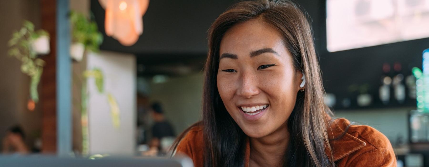 a woman smiling while working on laptop