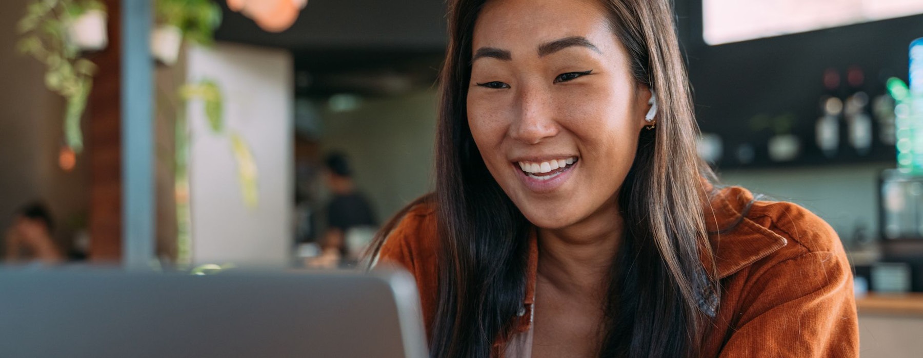 a woman smiling while working on laptop